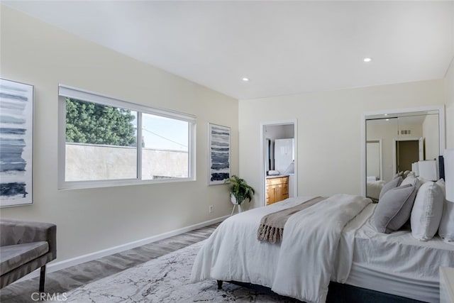 bedroom with wood-type flooring and ensuite bathroom