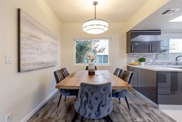 dining space with light wood-type flooring, plenty of natural light, and sink