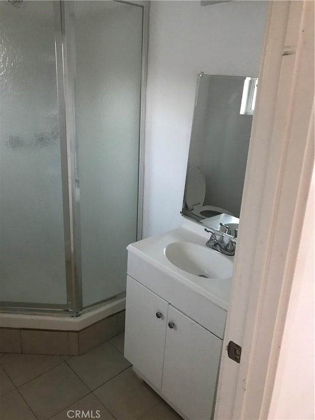 bathroom with tile patterned floors, vanity, and an enclosed shower