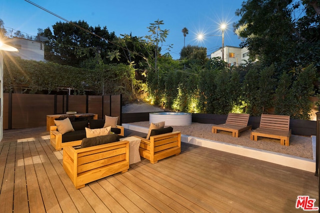 wooden deck with outdoor lounge area and a hot tub