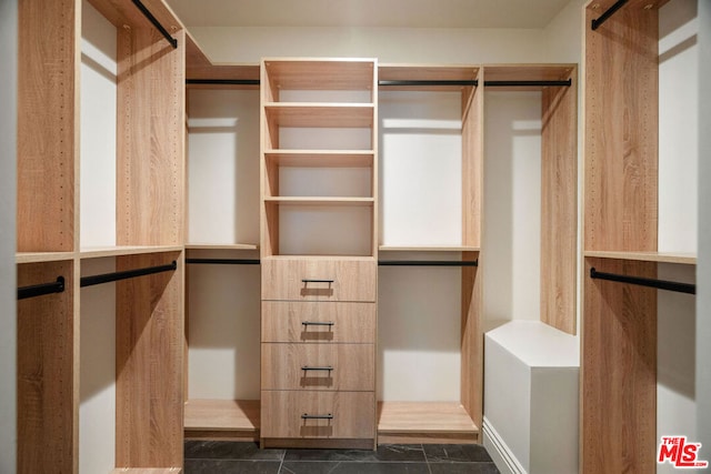 walk in closet with dark tile patterned floors