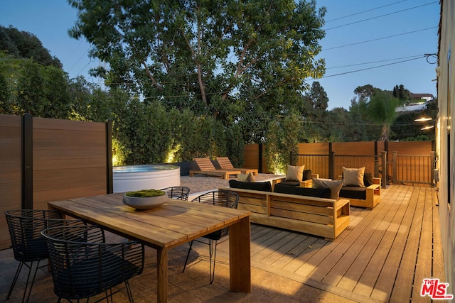 wooden terrace with a jacuzzi and an outdoor living space with a fire pit