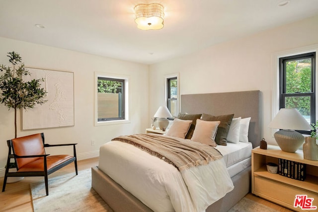 bedroom featuring light wood-type flooring and multiple windows