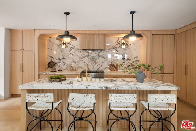 kitchen with pendant lighting and a center island with sink