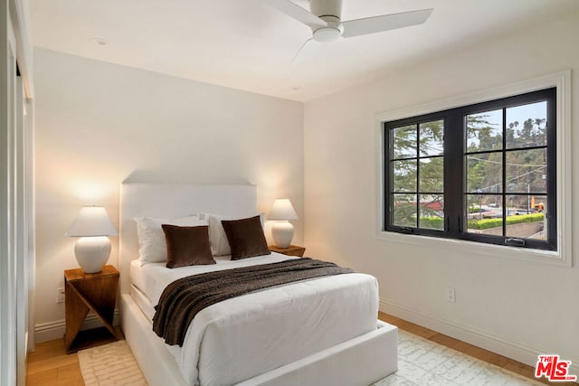 bedroom with light hardwood / wood-style flooring and ceiling fan