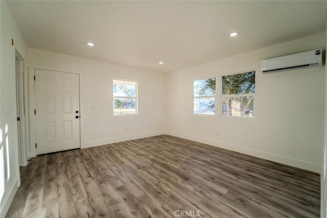 empty room featuring wood-type flooring and a wall mounted AC