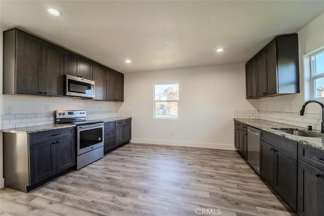 kitchen featuring a wealth of natural light, sink, light hardwood / wood-style flooring, and appliances with stainless steel finishes