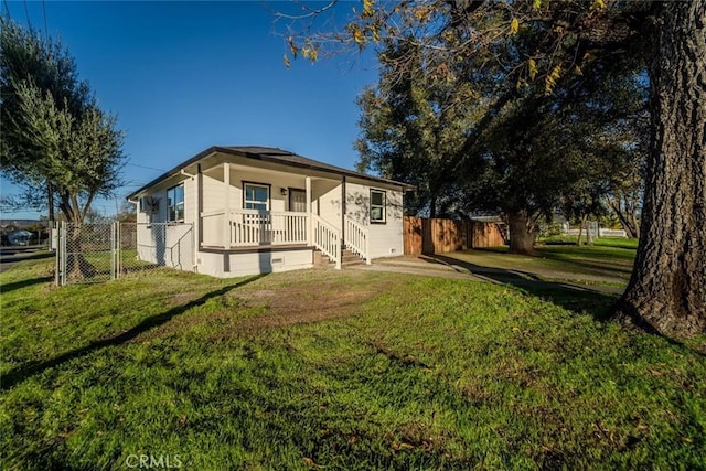 rear view of property with a lawn and covered porch