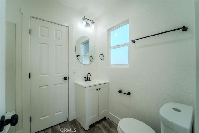 bathroom featuring vanity, wood-type flooring, and toilet