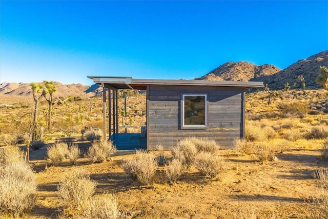 view of home's exterior featuring a mountain view and an outdoor structure