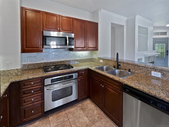 kitchen featuring appliances with stainless steel finishes, sink, backsplash, light stone counters, and light tile patterned floors