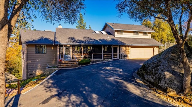 traditional-style home featuring aphalt driveway, crawl space, a chimney, and a garage