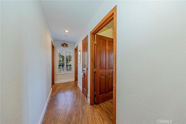 hall with wood finished floors and baseboards