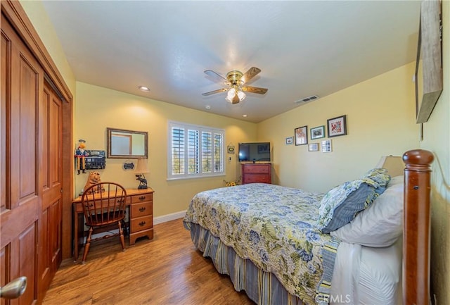 bedroom featuring baseboards, visible vents, ceiling fan, light wood-type flooring, and a closet