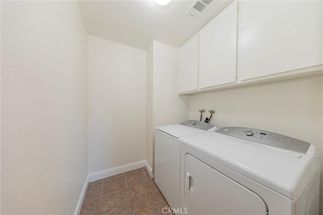 laundry room with washing machine and clothes dryer and cabinets