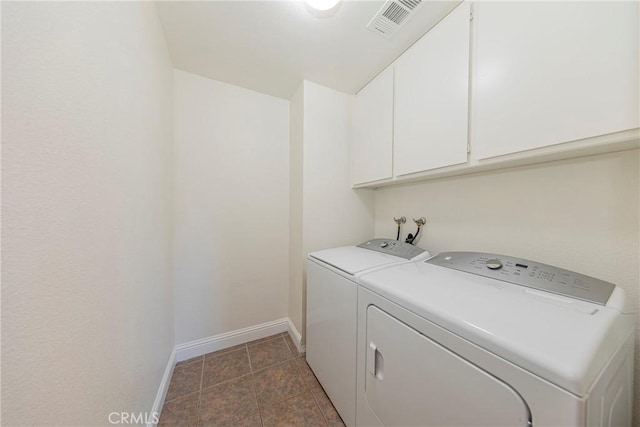 laundry area featuring visible vents, baseboards, cabinet space, tile patterned floors, and washer and clothes dryer