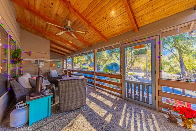 sunroom / solarium featuring ceiling fan, lofted ceiling with beams, and wood ceiling