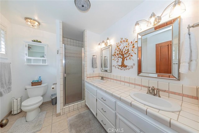 bathroom featuring double vanity, a sink, toilet, and tile patterned floors