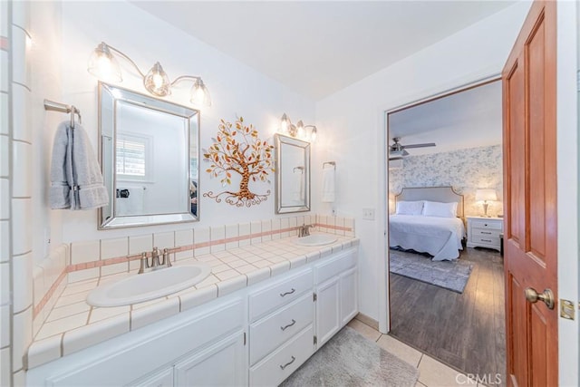 bathroom with connected bathroom, a ceiling fan, a sink, and double vanity