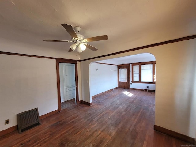 spare room featuring crown molding, dark wood-type flooring, and ceiling fan