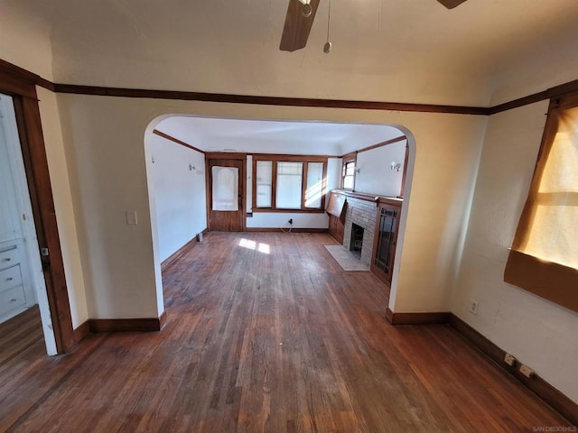 unfurnished living room with dark hardwood / wood-style flooring, a fireplace, and ceiling fan