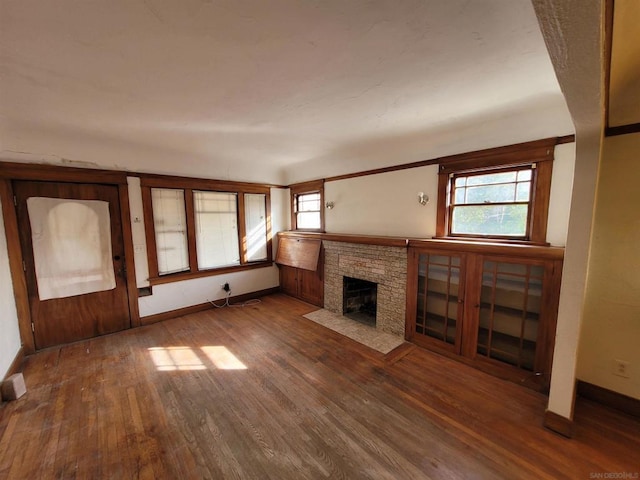 unfurnished living room with a wealth of natural light and dark wood-type flooring