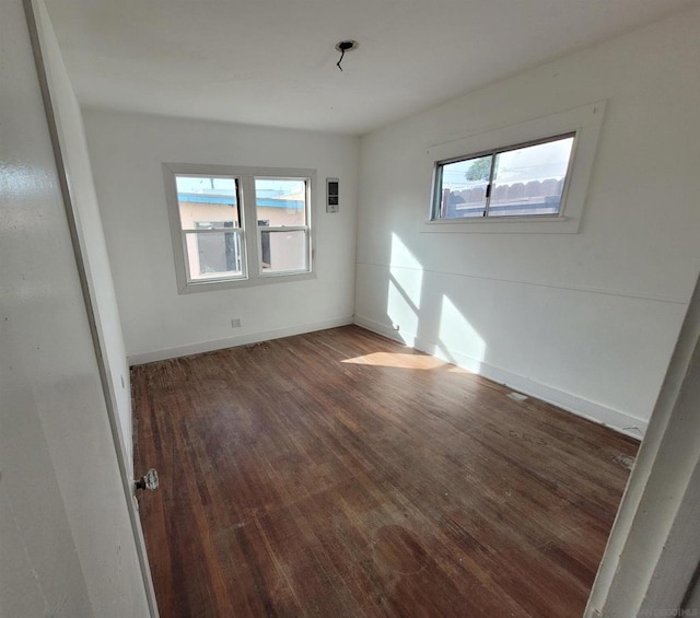 unfurnished room with dark hardwood / wood-style flooring and a healthy amount of sunlight