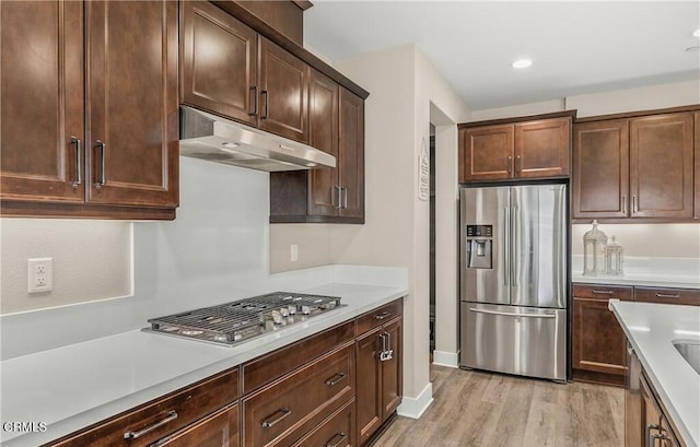 kitchen featuring light hardwood / wood-style floors, dark brown cabinetry, and stainless steel appliances