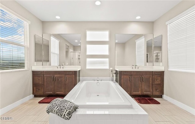 bathroom with plus walk in shower, vanity, and hardwood / wood-style flooring