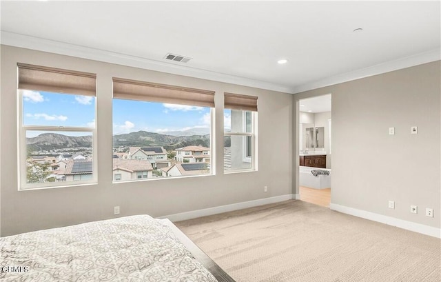 carpeted bedroom with multiple windows, a mountain view, ensuite bathroom, and ornamental molding