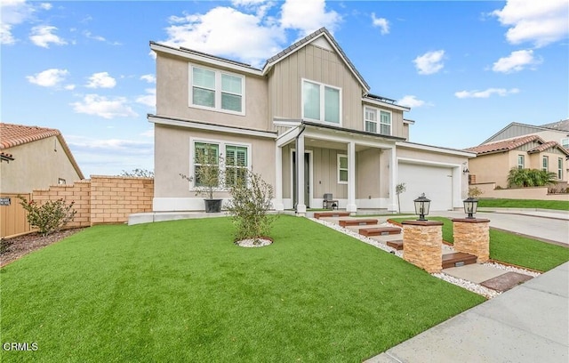 view of front of property with a garage, covered porch, and a front yard