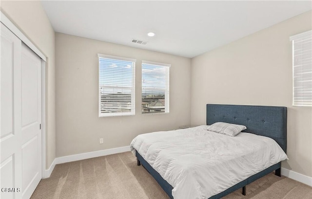 bedroom featuring light carpet and a closet