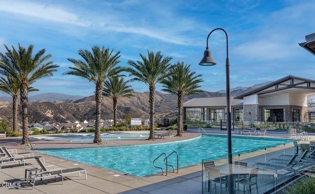 view of swimming pool featuring a mountain view and a patio