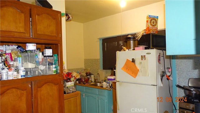 kitchen with sink, white refrigerator, and tasteful backsplash