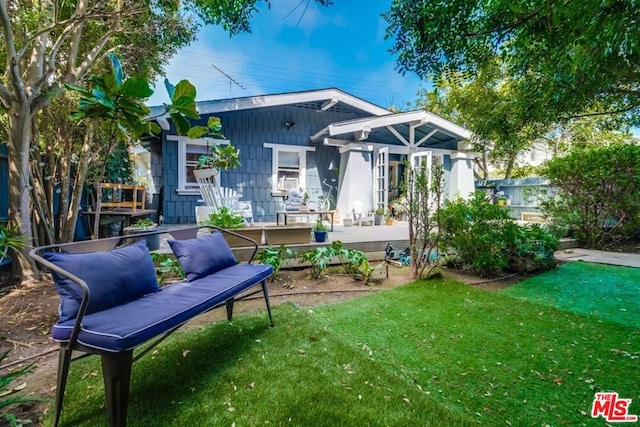 rear view of house featuring a yard