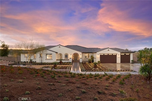 mediterranean / spanish-style home with a garage