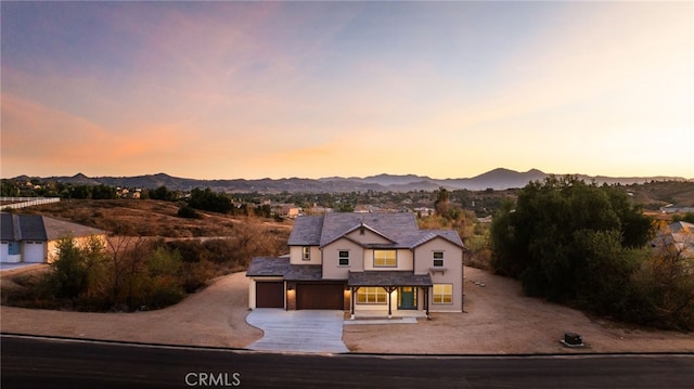 view of front of property with a garage, a mountain view, and concrete driveway