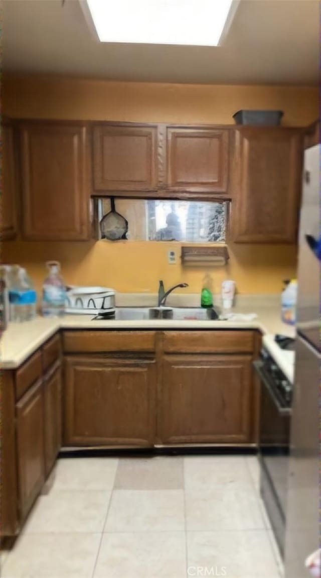 kitchen featuring range, sink, and light tile patterned floors