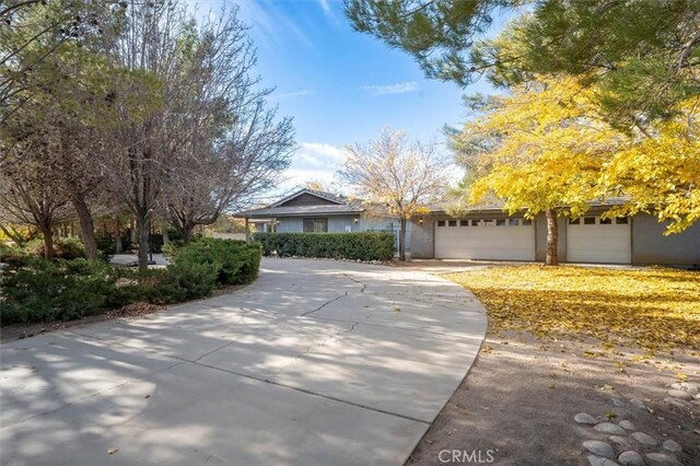 view of property hidden behind natural elements featuring a garage