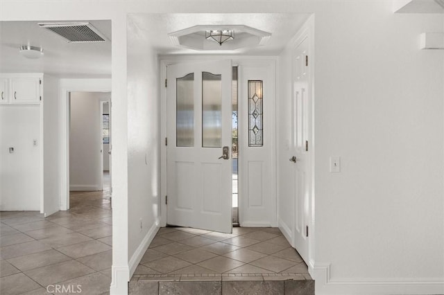 tiled foyer entrance featuring a tray ceiling