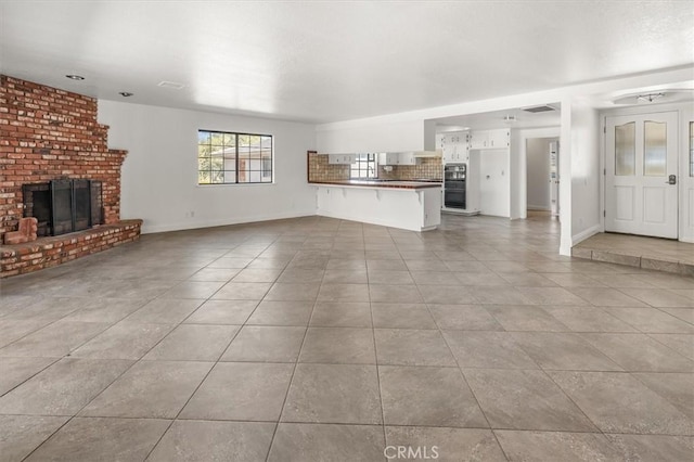 unfurnished living room featuring a fireplace and light tile patterned floors