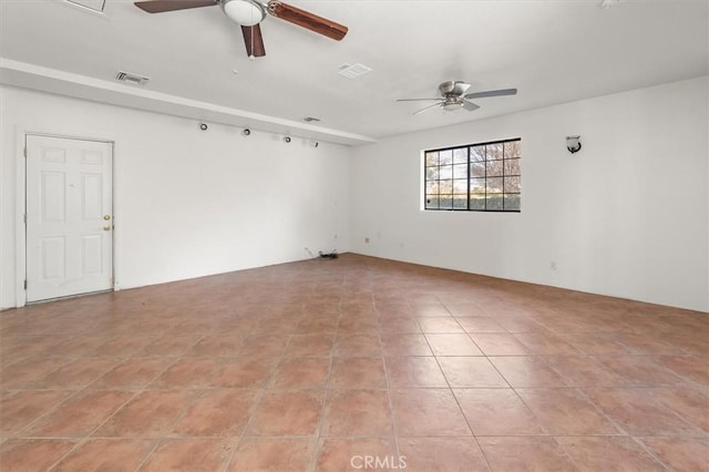 tiled spare room featuring ceiling fan