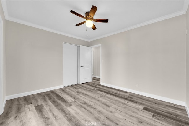 spare room with ceiling fan, light wood-type flooring, and crown molding