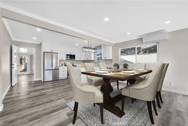 dining space featuring a wall mounted air conditioner, wood-type flooring, and crown molding