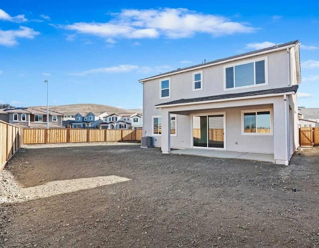 rear view of property featuring central air condition unit and a patio