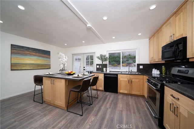 kitchen featuring sink, a center island, dark wood-type flooring, a breakfast bar area, and black appliances