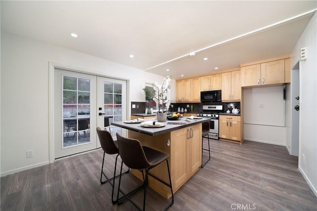 kitchen featuring a kitchen bar, french doors, gas stove, light brown cabinets, and a kitchen island