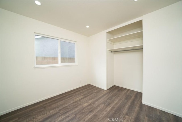 unfurnished bedroom featuring dark hardwood / wood-style flooring and a closet