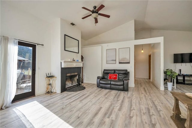 living room featuring vaulted ceiling, ceiling fan, and light wood-type flooring