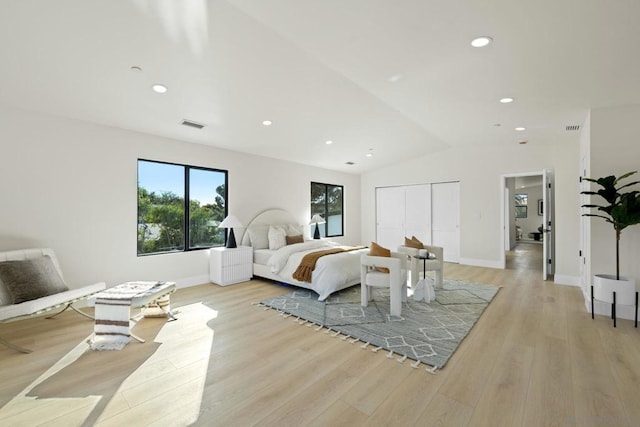 bedroom featuring light wood-type flooring and vaulted ceiling